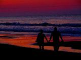 Insieme mano nella mano sulla spiaggia al tramonto