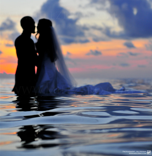 Amore tra sposini immersi in oceano romantico