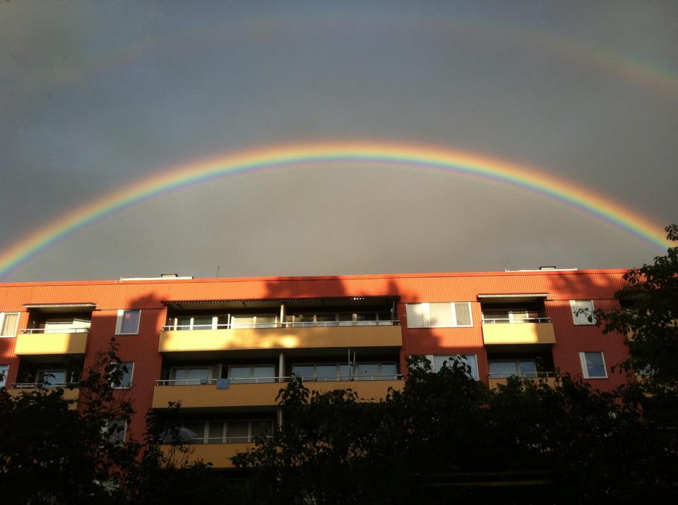 Arcobaleno che sembra abbracciare grossa palazzina