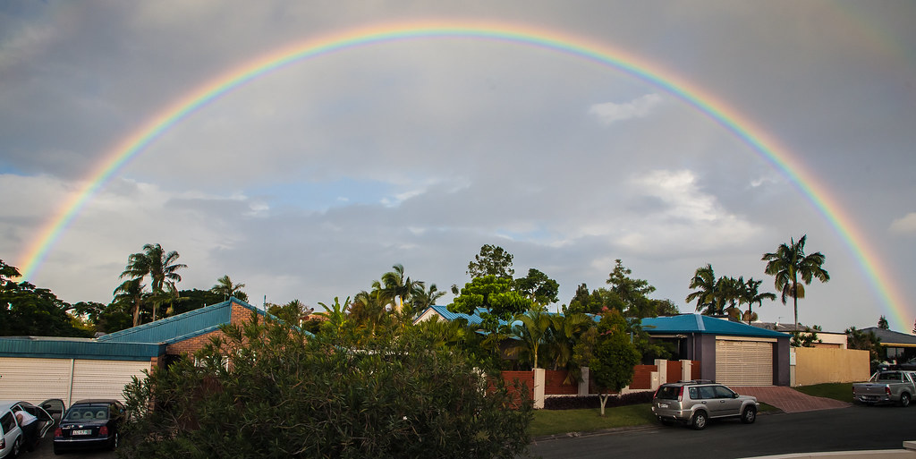 Arcobaleno intero su città con palme