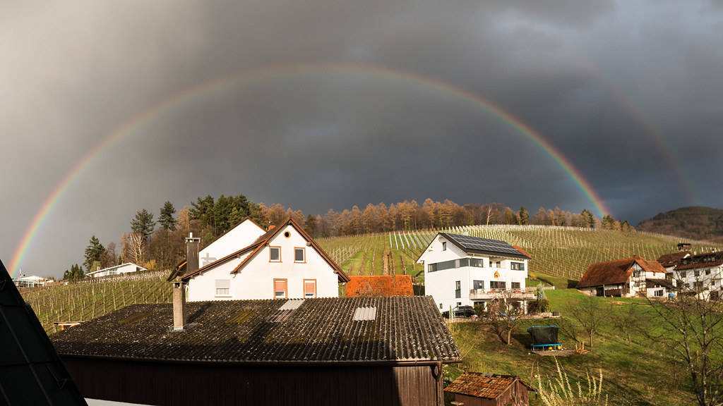 Arcobaleno sopra casette bianche di campagna