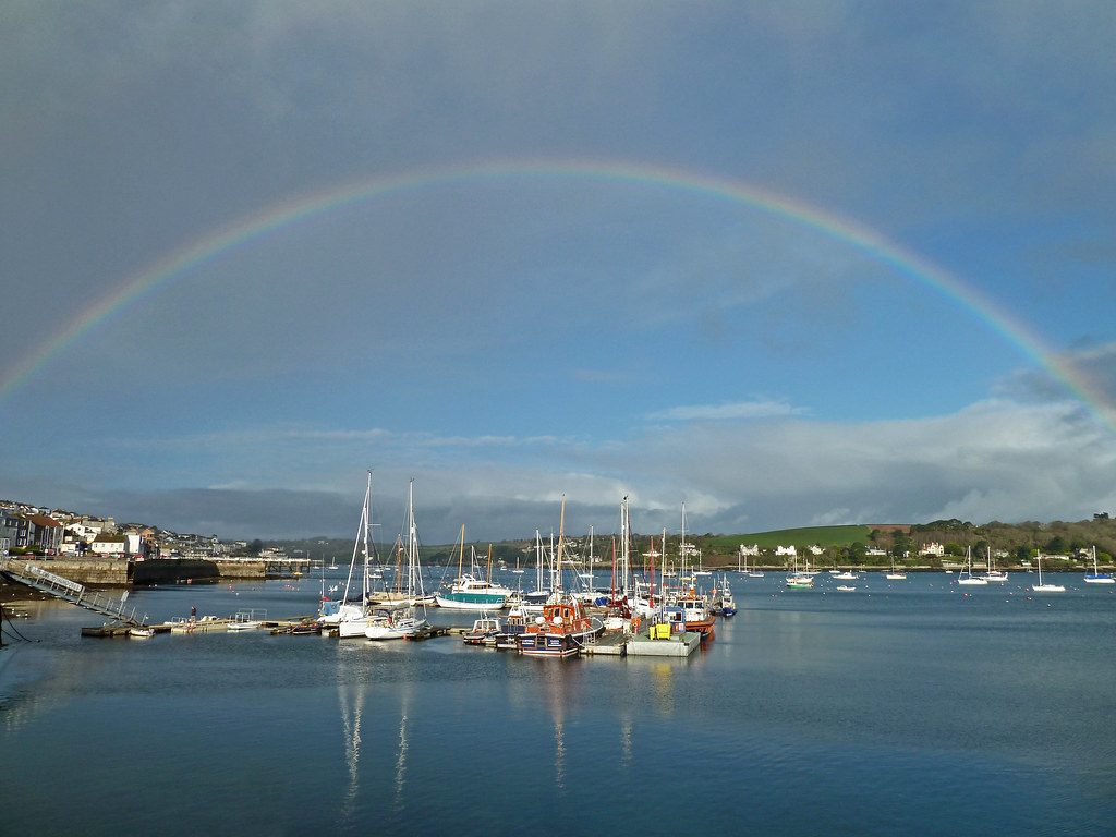 Arcobaleno sul mare quieto con tante belle barche