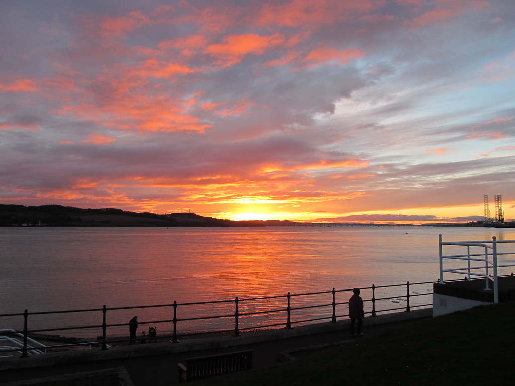 Baia al tramonto con bel cielo nuvoloso e sole basso