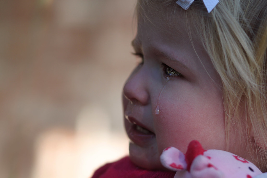 Bambina adorabile con le lacrime agli occhi che suscita tristezza