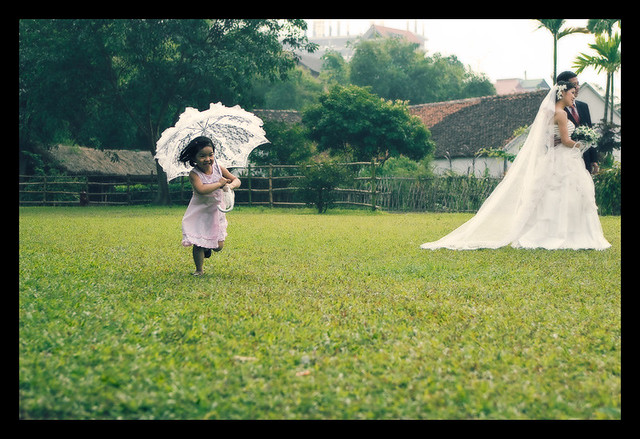Bambina dolcissima con ombrellino che corre verso la sposa