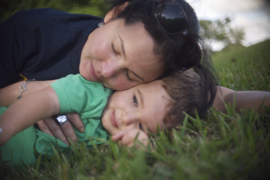 Bambino e madre sul prato per un momento di tenerezza