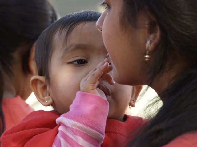 Bambino in braccio che tocca la bocca della madre con terezza