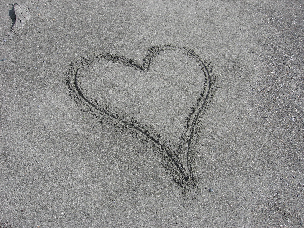 Bel cuore sulla spiaggia con sabbia fine