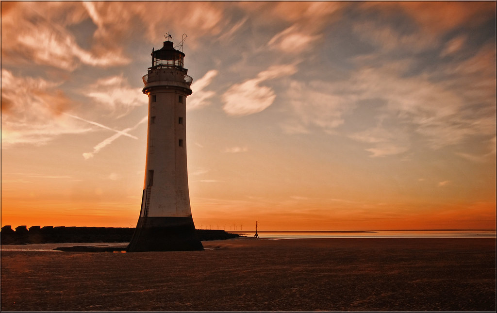 Bellissimo faro investito dalla luce arancione del tramonto