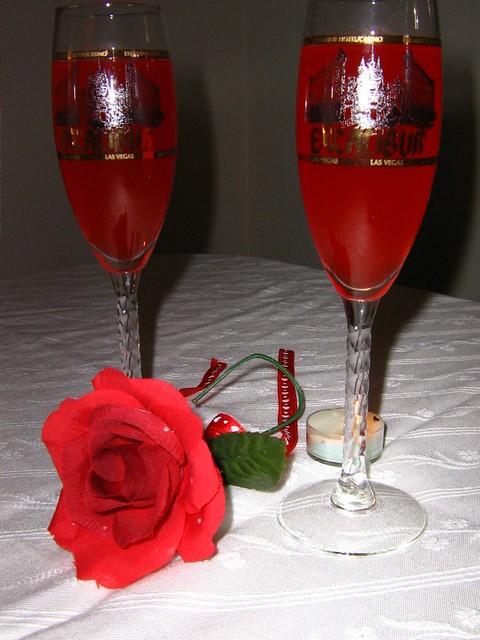 Bicchieri di vino e rosa rossa per cena