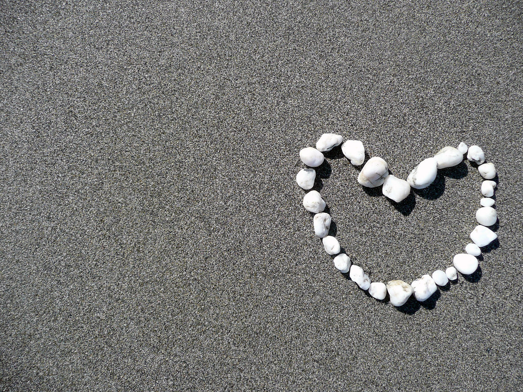 Cuore bianco costituito da pietre su sabbia molto fine