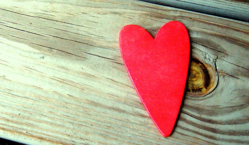 Cuore di carta rosso su asse di legno