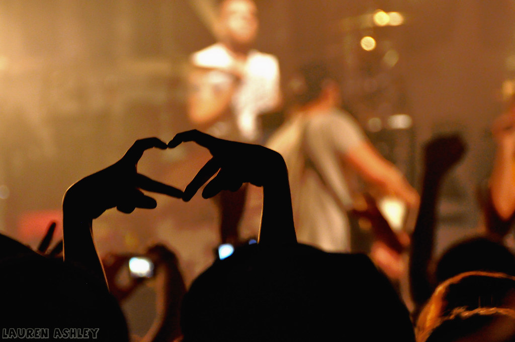 Cuore formato con dita di mani al concerto