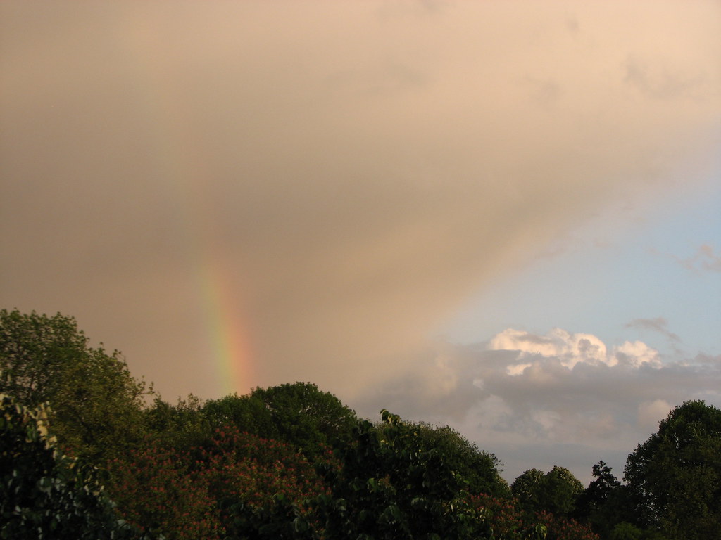 Pezzo di arcobaleno verso le grigie nuvole