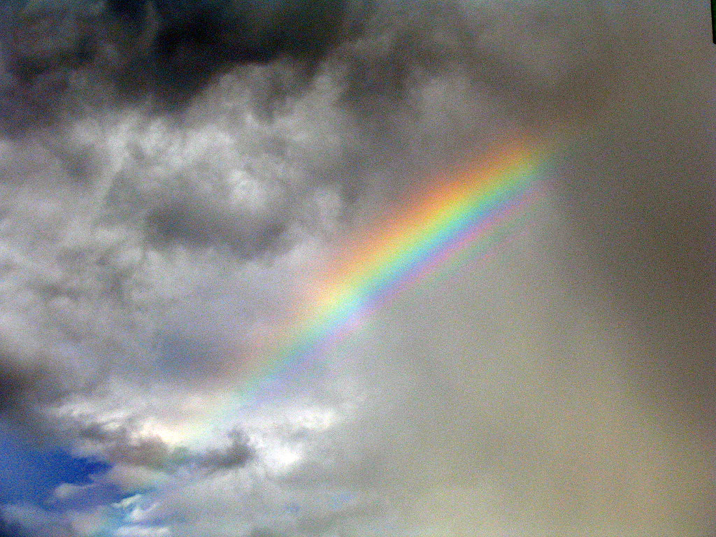 Piccola porzione di arcobaleno come pugnale che fende nuvole