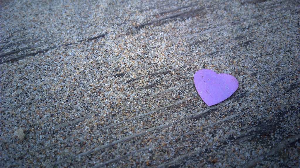 Piccolo cuore viola su sabbia