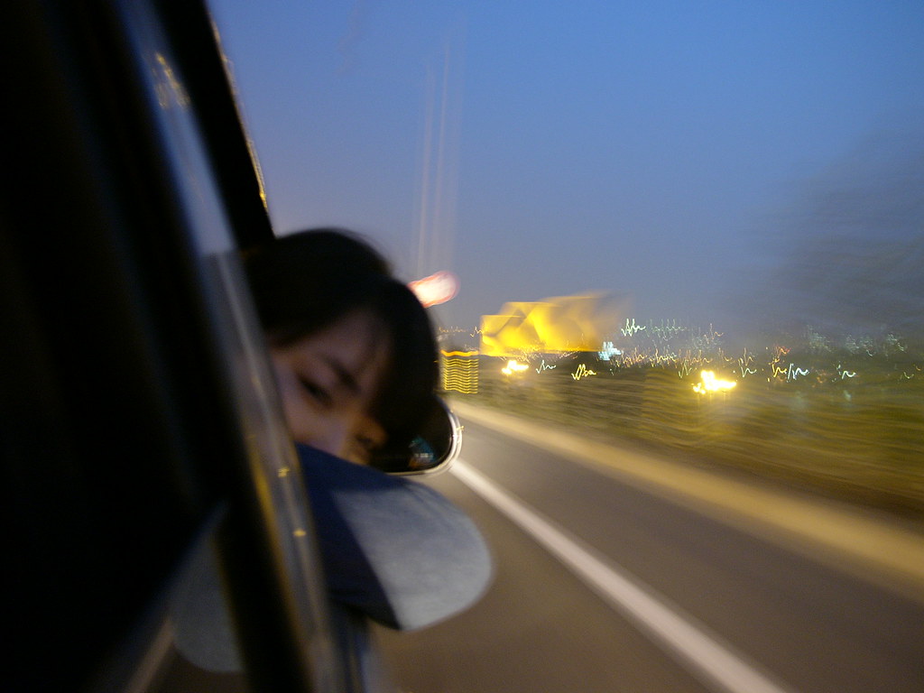 Ragazza coreana che si sporge dal finestrino della sua macchina