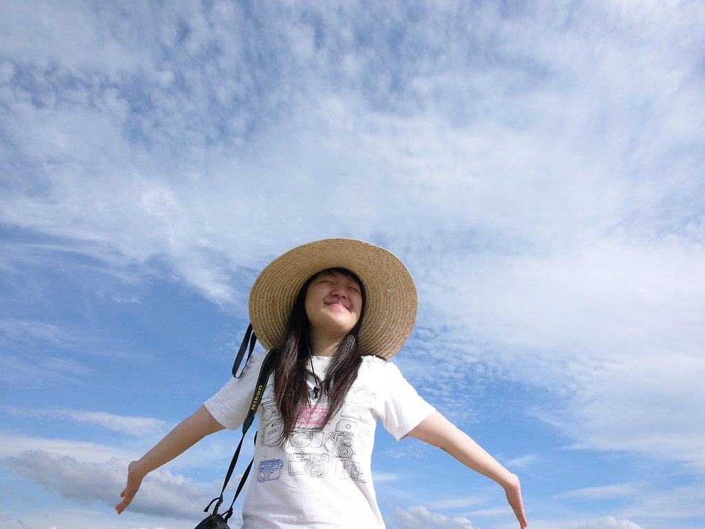 Ragazza coreana con cappello largo che sorride con braccia aperte