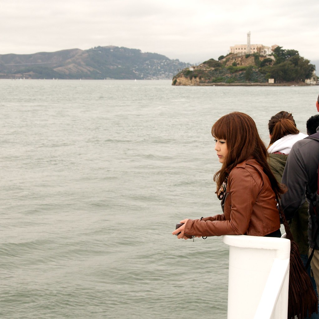 Ragazza giapponese affacciata sul mare con sguardo triste