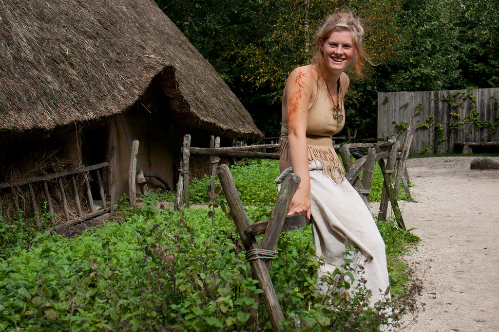Ragazza preistorica sorridente seduta su steccato al museo Archeon