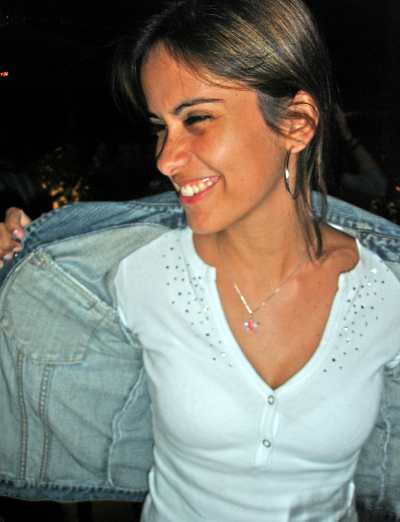 Ragazza sorridente che si toglie il giacchetto jeans