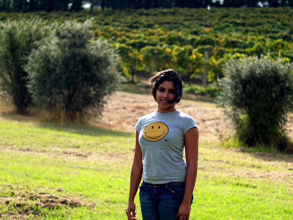 Ragazza sorridente con maglietta con faccina sorridente in bel campo