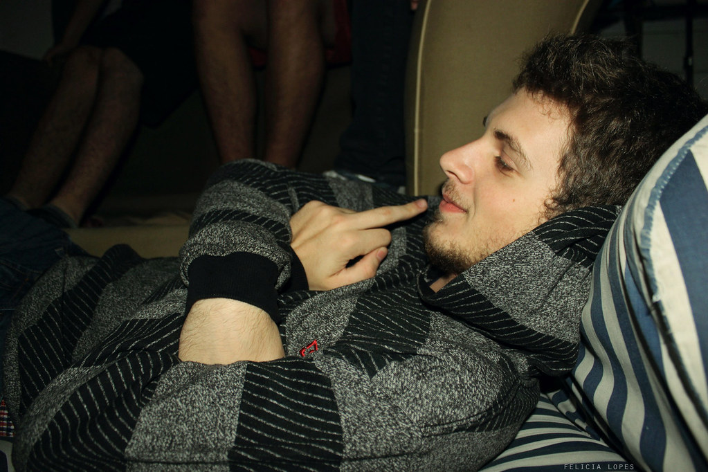 Ragazzo con maglione sul divano con braccia incrociate