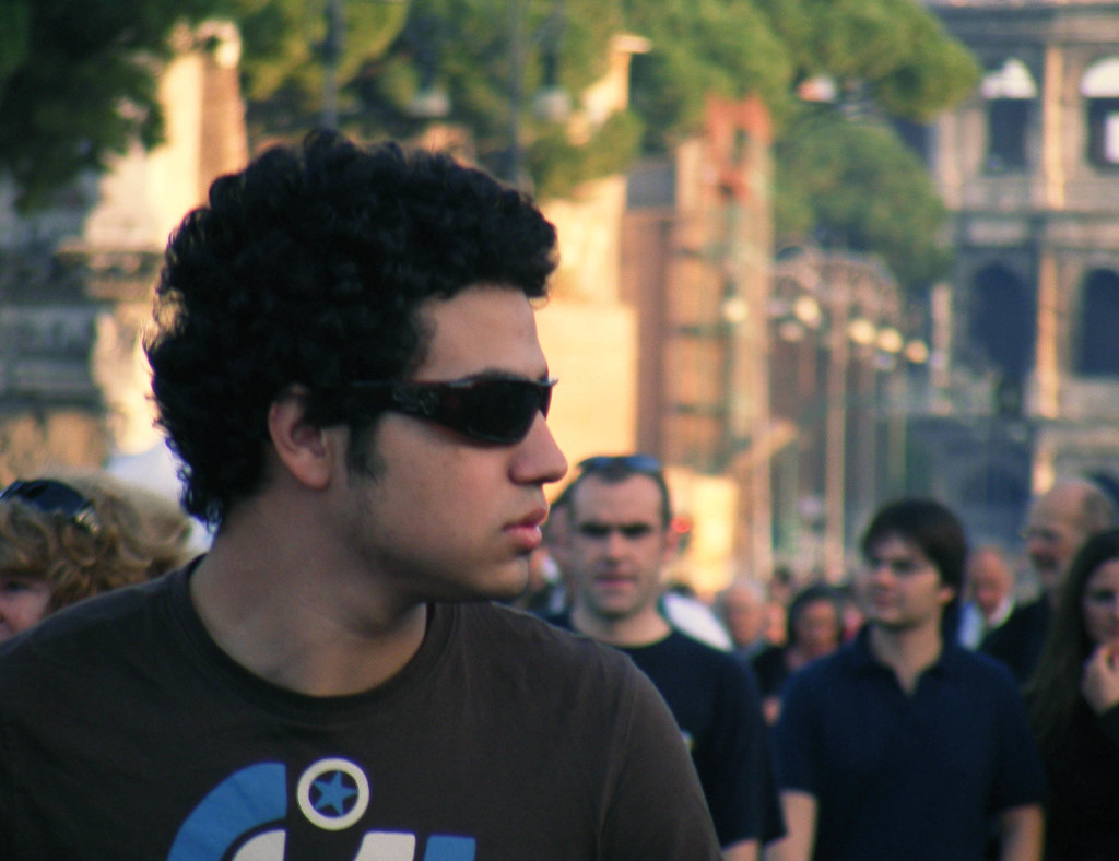 Ragazzo con occhiali da sole tra la gente a Roma vicino a Colosseo
