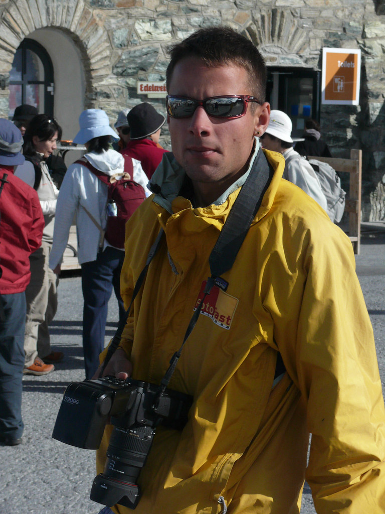 Ragazzo in impermeabile giallo con macchina fotografica a passeggio