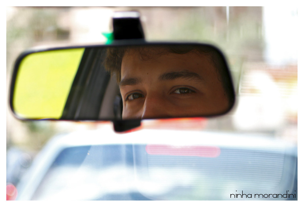 Riflesso di viso di guidatore di automobile su specchietto