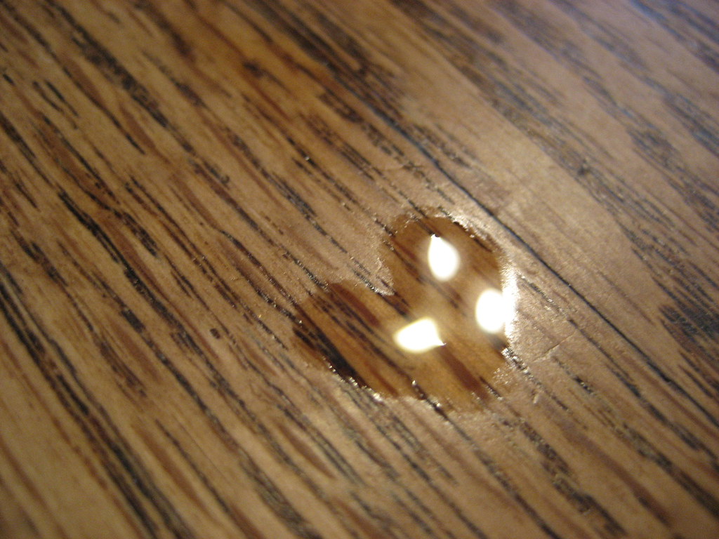 Segno di acqua a forma di cuore su tavolo marrone