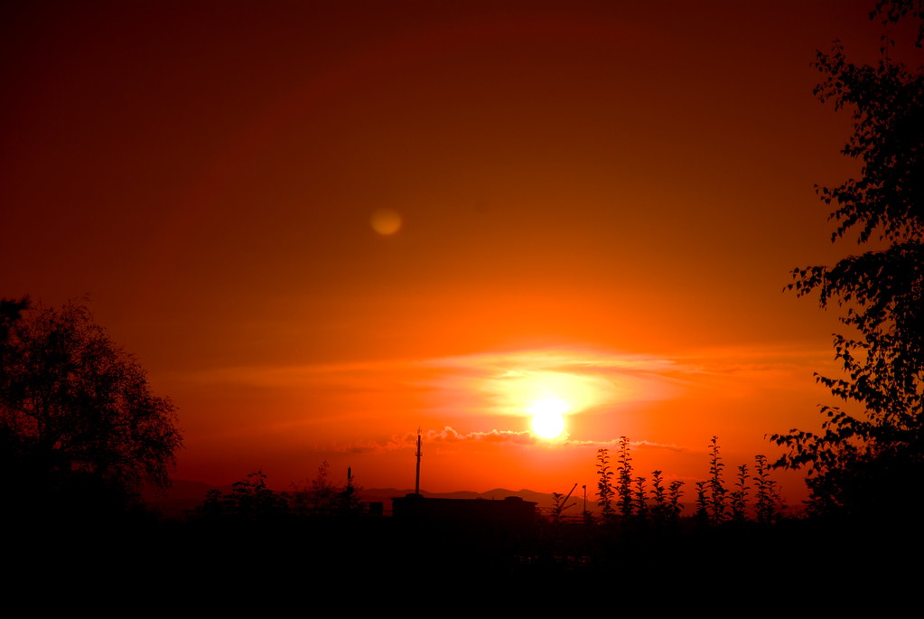 Tramonto con cielo arancione e sole lontano