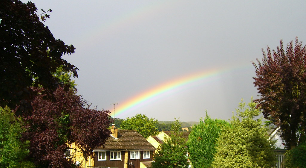 Tratto di arcobaleno che sembra partire da bella villa nel verde