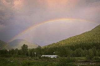 Arcobaleno che si estende tra montagne
