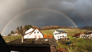 Arcobaleno sopra casette bianche di campagna