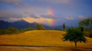 Arcobaleno spezzato da una nuvola in paesaggio molto pittoresco