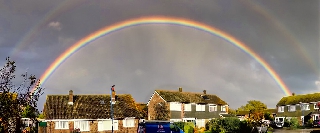 Doppio arcobaleno sopra grandi ville