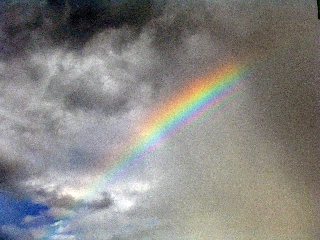 Piccola porzione di arcobaleno come pugnale che fende nuvole