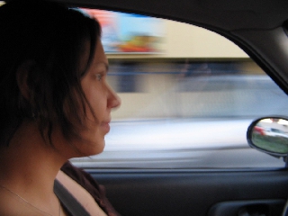 Ragazza di profilo al volante mentre guida in città