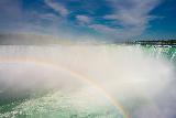 Immagine bassa Arcobaleno a bassa quota davanti a bella cascata