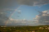 Immagine arcobaleno Arcobaleno che si proietta da nuvola su paesino