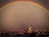 Arcobaleno con dominante color arancio sulla città