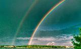 Arcobaleno con doppio in cielo verde su prato verde