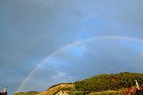 Arcobaleno con minuscolo doppio in cielo celeste