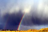 Arcobaleno doppio che fuoriesce da nuvole molto minacciose