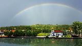 Arcobaleno in bellissimo paesaggio da cartolina con verde e mare