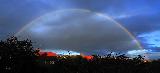 Immagine arcobaleno Arcobaleno in cielo blu sopra tetti di case rossi