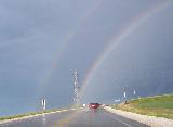 Arcobaleno mistico sopra una strada tra il verde