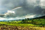 Immagine arcobaleno Arcobaleno seminascosto dalle nuvole sopra bel paesaggio