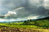 Arcobaleno seminascosto dalle nuvole sopra bel paesaggio